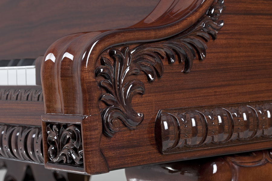 An ornate hand-carved piano arm design